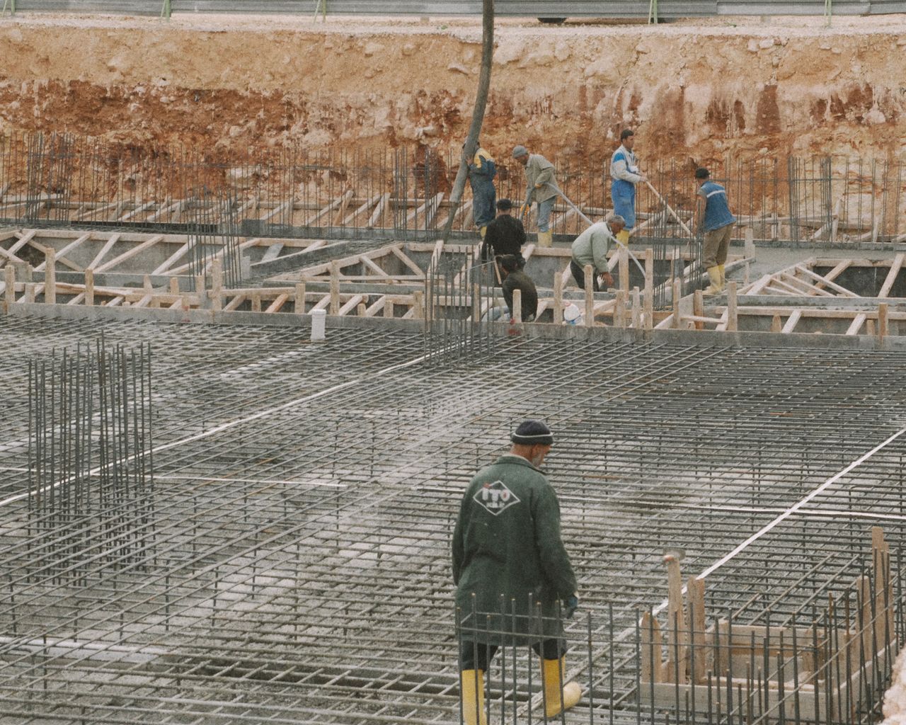 services-01 Workers building a foundation with rebar at a construction site.